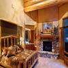stone fireplace and log mantle in log home bedroom